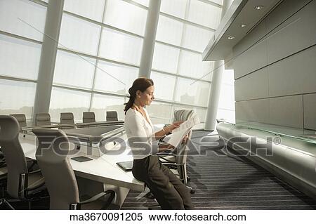 Businesswoman reading paperwork in conference room View Large Photo Image Stock Photography - Businesswoman reading paperwork in conference room. Fotosearch