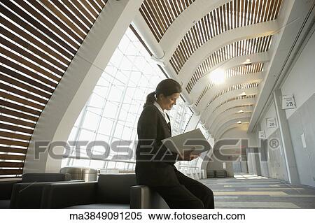 Stock Photography - Businesswoman reading paperwork in conference room. Fotosearch