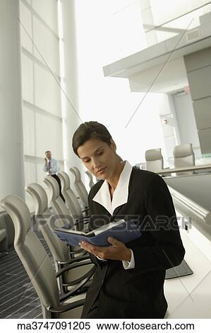 Stock Photography - Businesswoman with day timer in conference room. Fotosearch