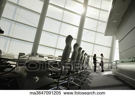 Stock Photography - Businesswomen talking in conference room. Fotosearch