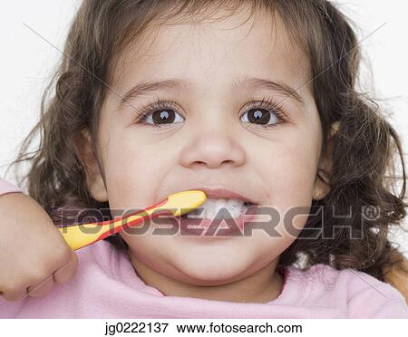 Stock Photo - Close up portrait of little girl brushing teeth. Fotosearch