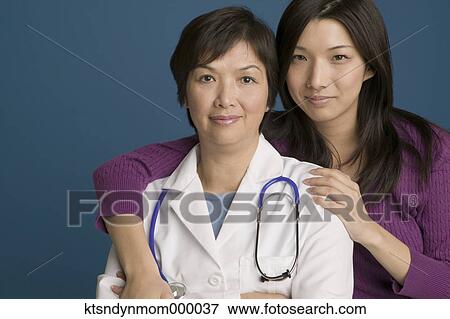 Doctor posing for the camera with her daughter View Large Photo Image Stock Photo - Doctor posing for the camera with her daughter. Fotosearch
