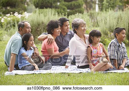 Stock Photograph - Family sitting on blanket. Fotosearch