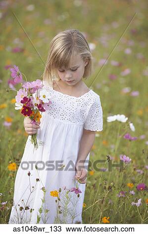Girl in field picking wildflowers View Large Photo Image Stock Image - Girl in field picking wildflowers. Fotosearch