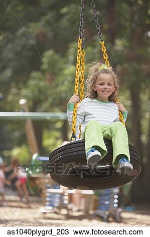 Girl swinging on tire swing View Large Photo Image Stock Image - Girl swinging on tire swing. Fotosearch