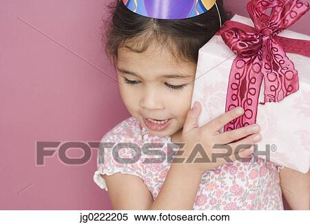 Stock Photography - Girl with birthday gift and hat. Fotosearch