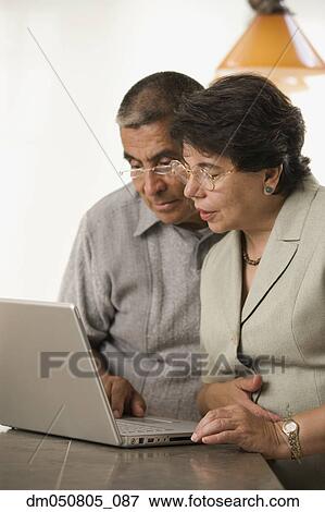 Stock Photo - Mature couple working on laptop. Fotosearch