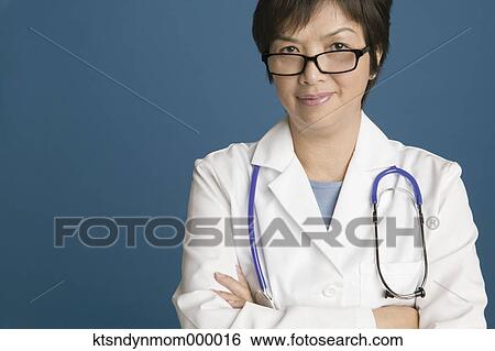 Stock Photograph - Middle aged female doctor posing for the camera with arms crossed. Fotosearch