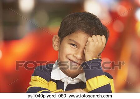 Stock Image - Portrait of boy with hand over face. Fotosearch