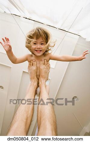 Stock Image - Portrait of girl playing airplane with father. Fotosearch