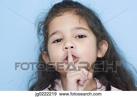 Stock Photo - Portrait of girl with finger over mouth. Fotosearch