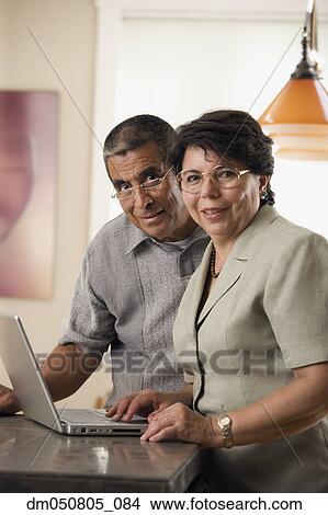 Portrait of mature couple with laptop View Large Photo Image Picture - Portrait of mature couple with laptop. Fotosearch