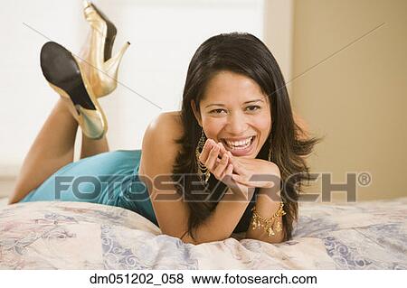 Portrait of woman laying on bed smiling View Large Photo Image Stock Photo - Portrait of woman laying on bed smiling. Fotosearch