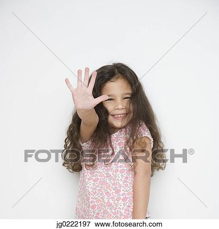 Portrait of young girl holding hand up in front of her View Large Photo Image Stock Photo - Portrait of young girl holding hand up in front of her. Fotosearch