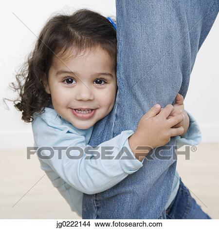 Picture - Portrait of young girl hugging leg of mother. Fotosearch