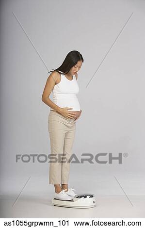 Pregnant woman weighing on scale View Large Photo Image Stock Image - Pregnant woman weighing on scale. Fotosearch