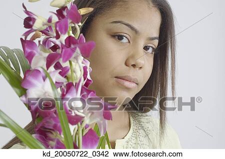 Stock Image - Teenage girl holding a bunch of purple flowers. Fotosearch