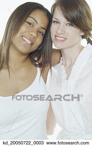 Stock Image - Teenage girls hugging for the camera. Fotosearch