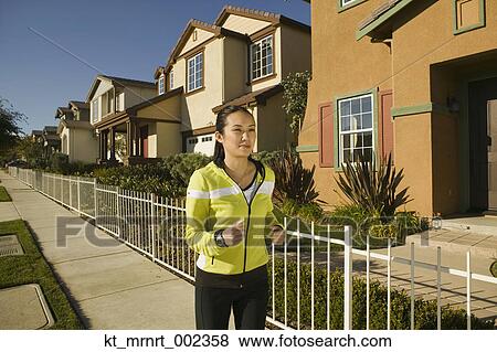 Stock Photo - Woman jogging in neighborhood. Fotosearch