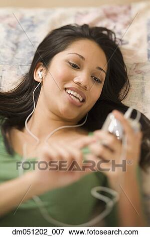 Stock Photo - Woman listening to music on an mp3 player. Fotosearch