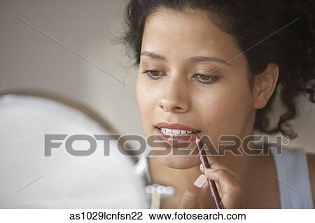 Woman putting on make-up View Large Photo Image Stock Image - Woman putting on make-up. Fotosearch