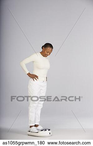 Woman weighing herself on scale View Large Photo Image Stock Image - Woman weighing herself on scale. Fotosearch