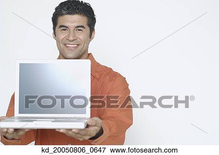 Stock Photo - Young man holding out his laptop. Fotosearch