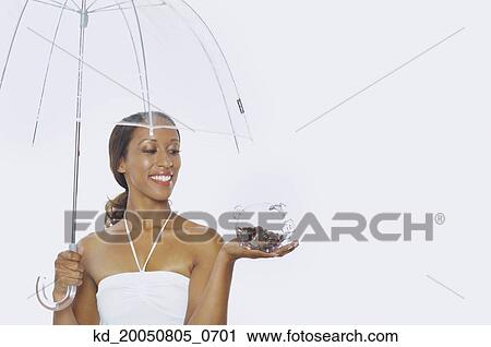 Young woman holding a piggy bank and an umbrella View Large Photo Image Stock Image - Young woman holding a piggy bank and an umbrella. Fotosearch