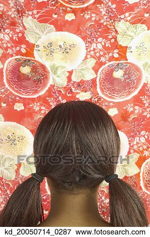 Young woman in pigtails looking at wallpaper View Large Photo Image Stock Photo - Young woman in pigtails looking at wallpaper. Fotosearch