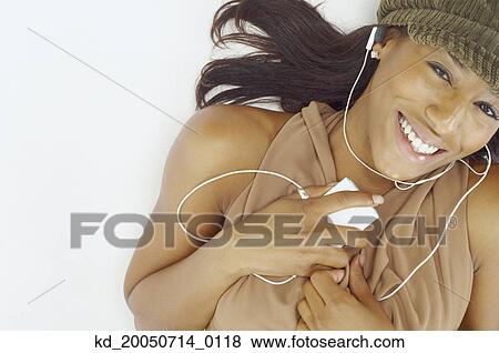 Young woman listening to an mp3 player View Large Photo Image Stock Photo - Young woman listening to an mp3 player. Fotosearch