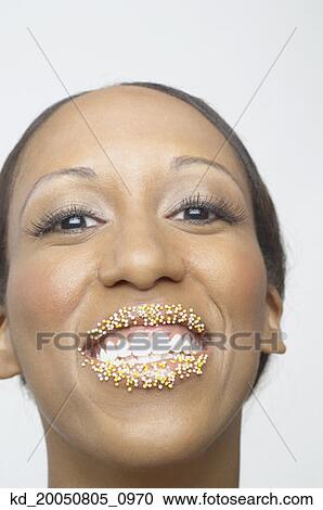 Stock Image - Young woman smiling with sprinkles on her lips. Fotosearch