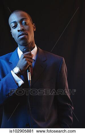 Stock Image - Businessman speaking into a microphone. Fotosearch