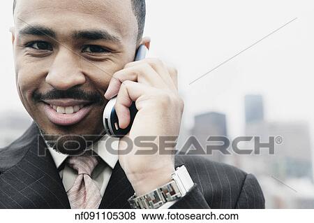 Stock Photo - Businessman talking on his cell phone. Fotosearch