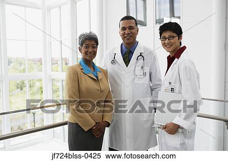 Stock Photography - Businesswoman and doctors smiling for the camera. Fotosearch