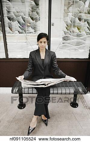 Picture - Businesswoman reading a newspaper. Fotosearch