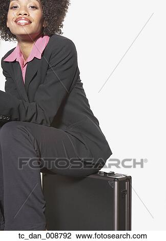 Businesswoman sitting on metal briefcase View Large Photo Image Stock Image - Businesswoman sitting on metal briefcase. Fotosearch