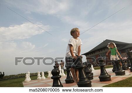 Children playing on life-size chess board View Large Photo Image Stock Photography - Children playing on life-size chess board. Fotosearch
