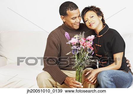 Stock Photo - Couple holding a vase of flowers. Fotosearch