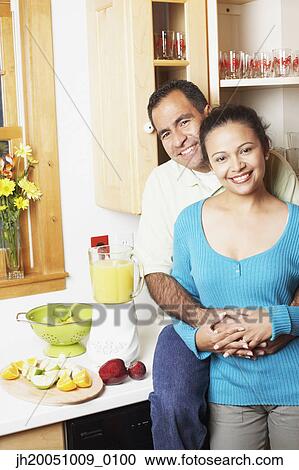 Couple hugging in their kitchen View Large Photo Image Stock Image - Couple hugging in their kitchen. Fotosearch