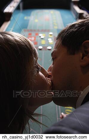Stock Image - Couple kissing at a gambling table. Fotosearch