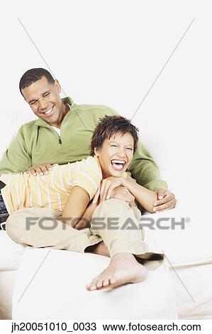 Stock Image - Couple relaxing together on the couch. Fotosearch