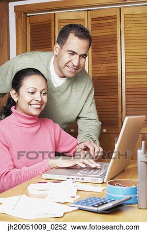 Stock Image - Couple using a laptop together. Fotosearch