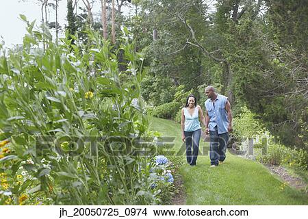 Couple walking on green lawn View Large Photo Image Picture - Couple walking on green lawn. Fotosearch