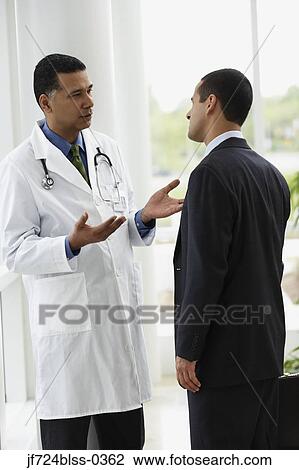 Stock Image - Doctor talking to a businessman. Fotosearch