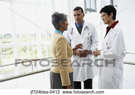 Stock Image - Doctors talking to businesswoman. Fotosearch