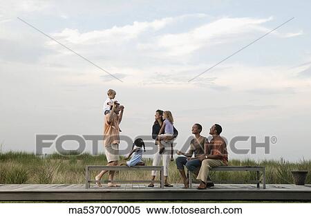 Stock Photography - Families playing on wooden benches. Fotosearch