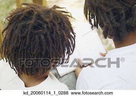 Stock Photo - Friends reading a book together. Fotosearch