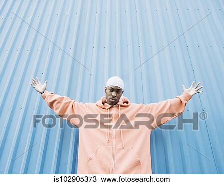 Low angle view of teenage boy holding his arms out View Large Photo Image Stock Image - Low angle view of teenage boy holding his arms out. Fotosearch