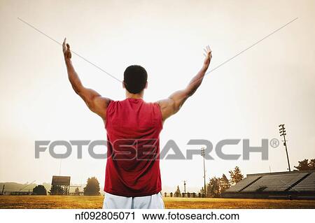 Male athlete holding his arms out on football field View Large Photo Image Stock Image - Male athlete holding his arms out on football field. Fotosearch