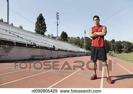 Stock Photo - Male athlete posing for the camera on a track. Fotosearch